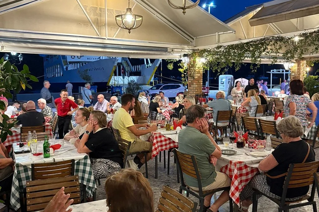 Full terrace with red-checked tablecloths in the evening