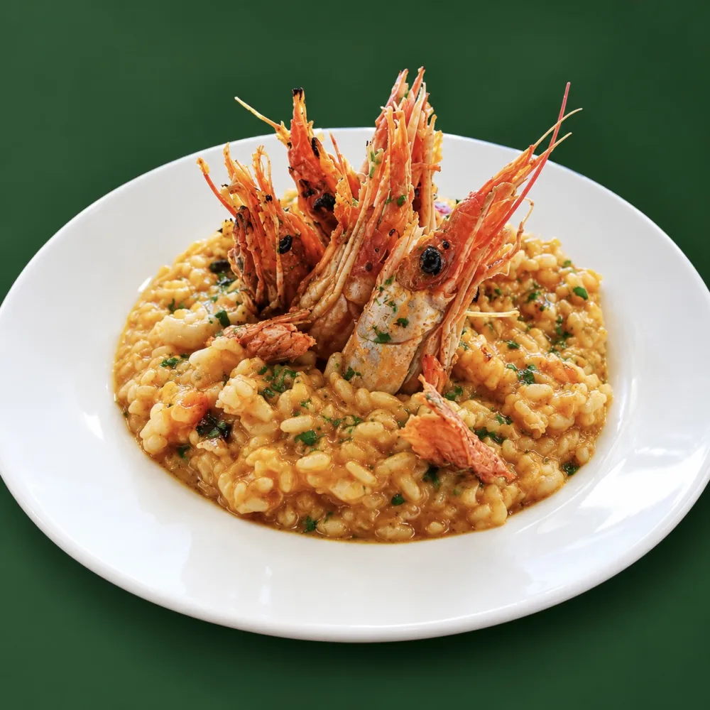 Seafood risotto topped with red prawns